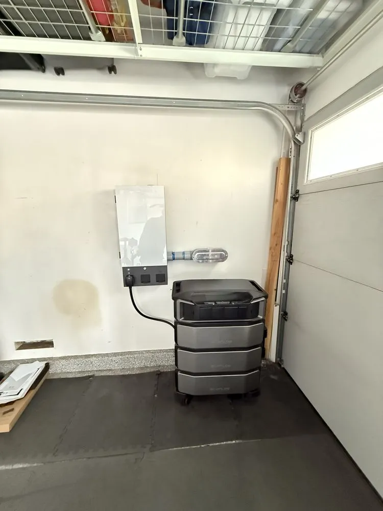 Battery-backup smart panel and home battery unit installed on a garage wall.