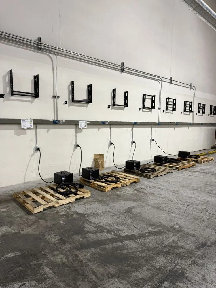 Commercial wall with surface-mounted conduit runs feeding a row of equipment boxes.